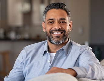 Man smiling while sitting in couch at home